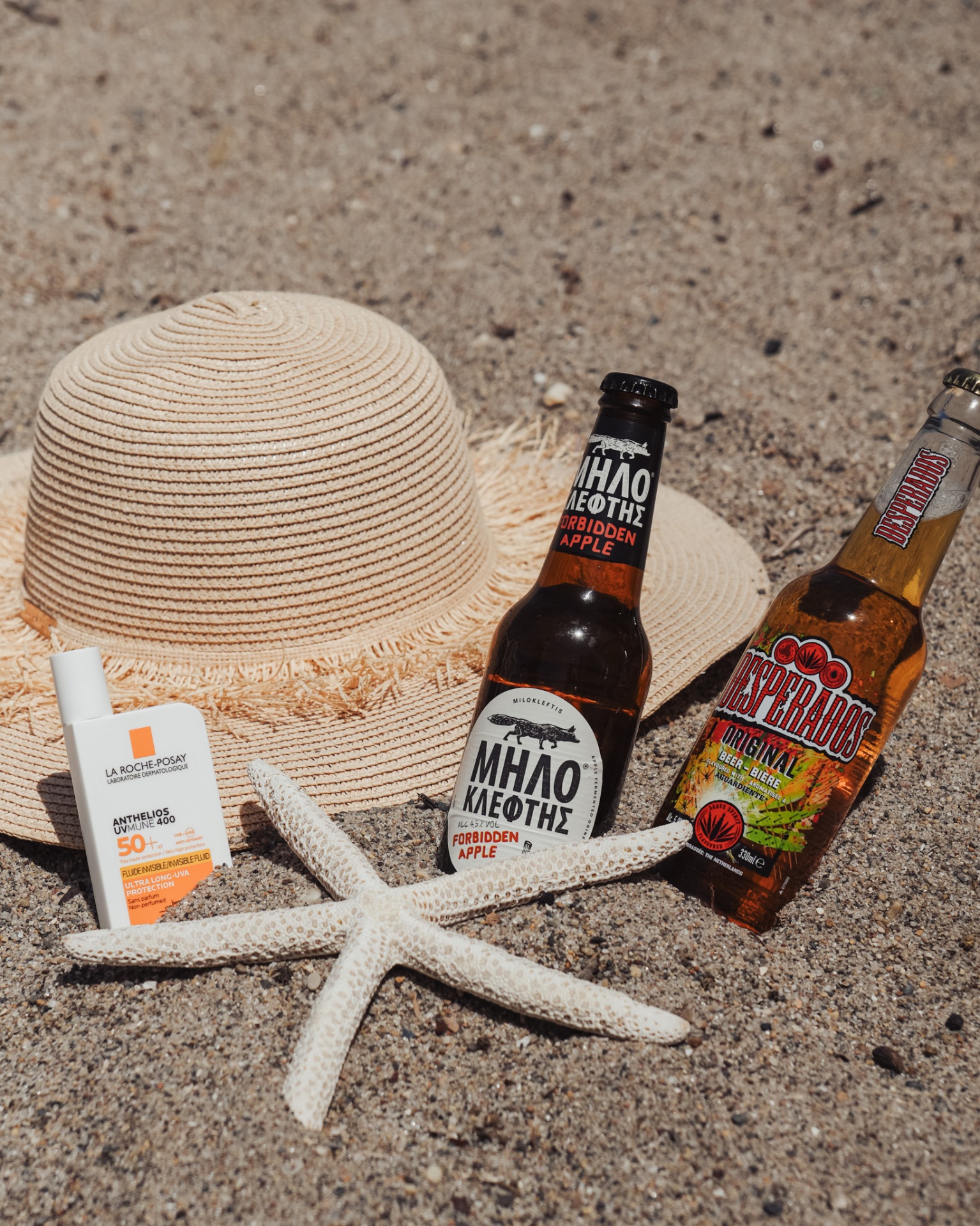 Sunny beach scene with hat, drinks and starfish