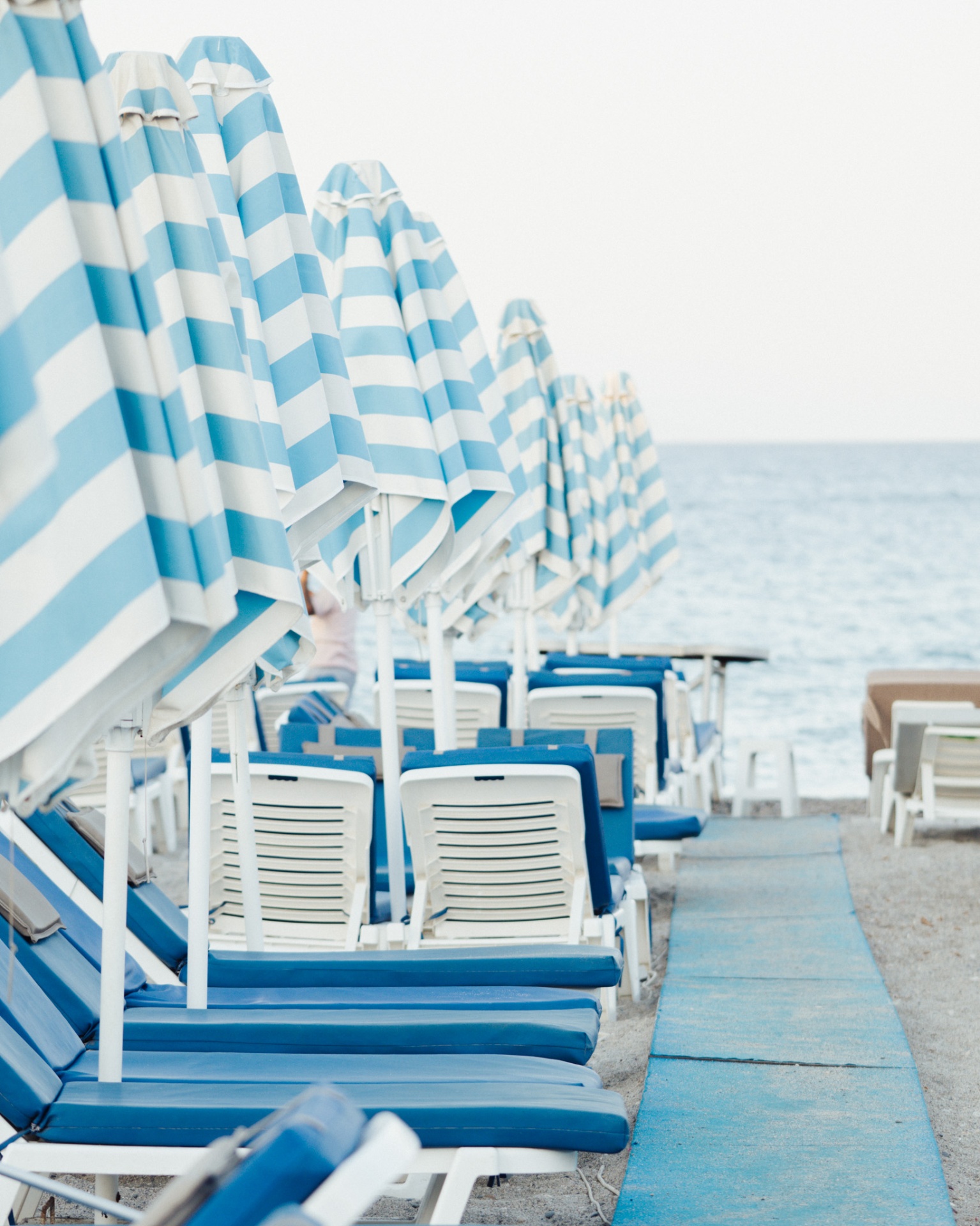 Blue striped beach umbrellas along the shore